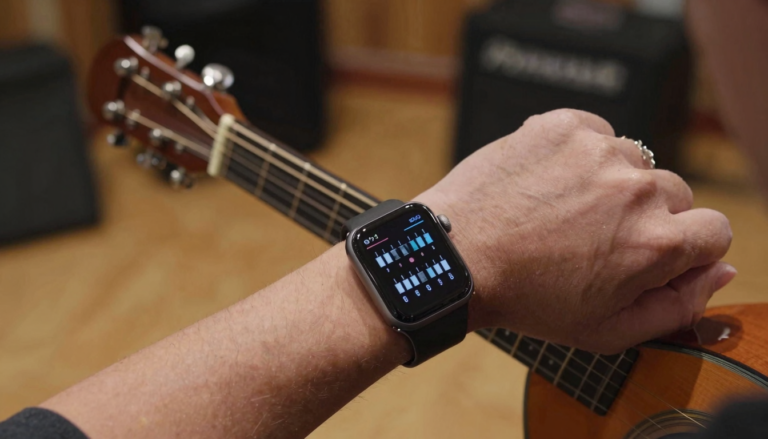 Musician reading a chord chart on an Apple Watch while holding a guitar
